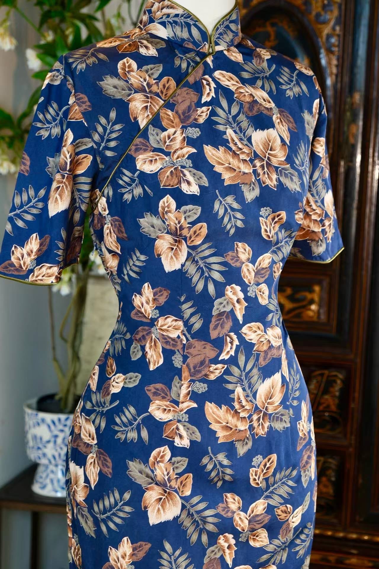 50年代 - 五十年代台湾风华：蓝地棕叶“百草比德”印花古董旗袍 — 迁徙年代的植物图腾与行走的乡愁 | 1950s - 1950s Taiwan Elegance: A Vintage Indigo Cheongsam with "Virtuous Botanical" Brown Leaf Print — A Narrative of Migratory Plant Totems and Walking Nostalgia