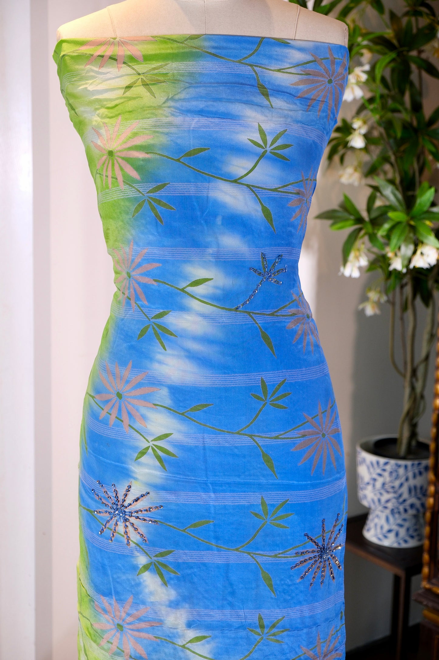 布料名 - 翠羽晴空：青草绿至湛蓝扎染渐变真丝面料，缀手工亮片刺绣野菊蔓藤与星芒繁花 | Fabric Name - Verdant Sky: Grass Green to Azure Tie-Dye Gradient Silk Featuring Hand-Embroidered Sequin Daisies and Starburst Flora