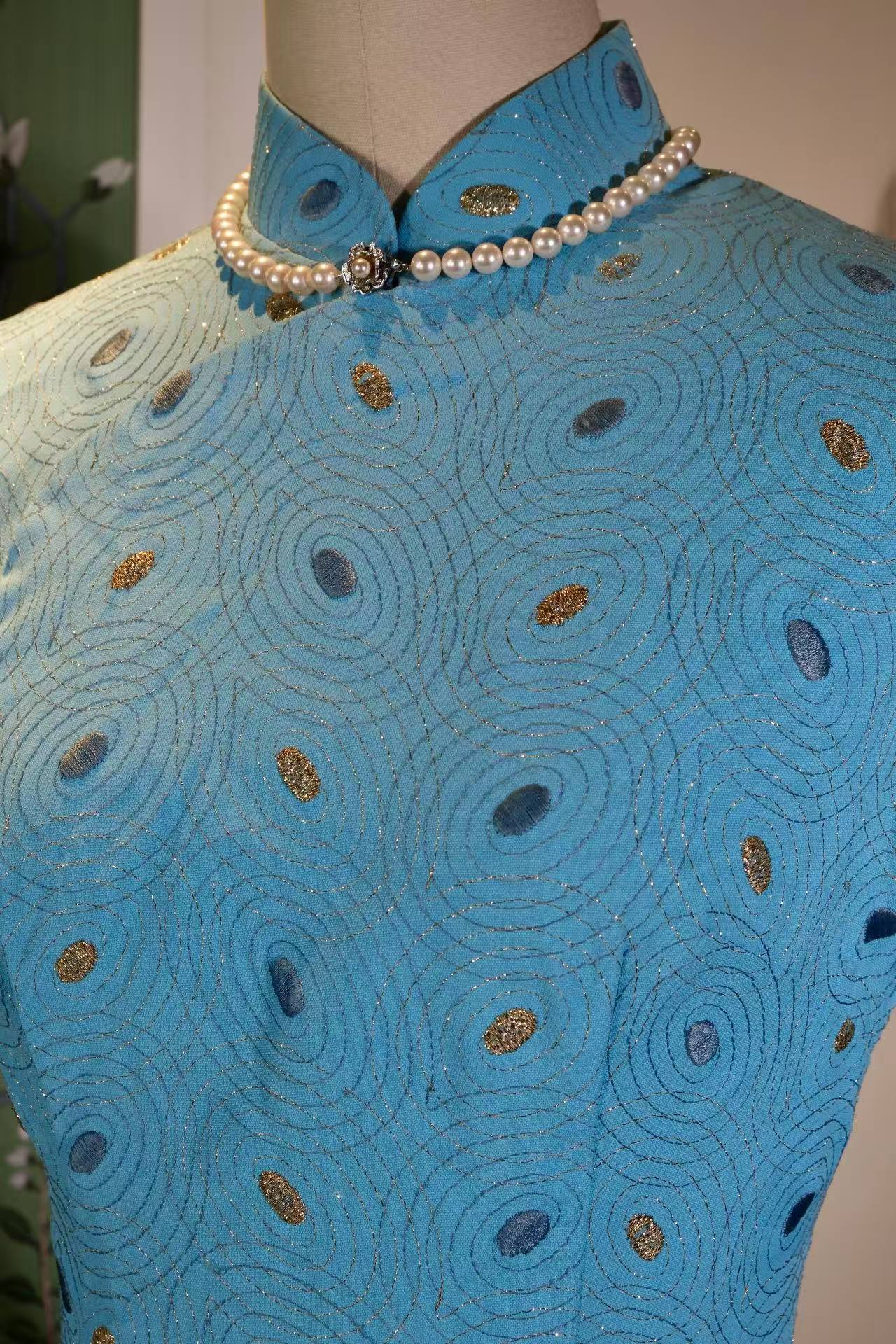 孔雀蓝韵，金线流光——一件五十年代港产旗袍的东方叙 |  "Peacock Radiance, Golden Streams of Light: The Eastern Narrative of a 1950s Hong Kong-Produced Qipao"